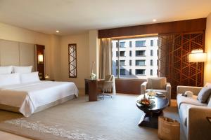 a hotel room with a bed and a living room at Jumeirah Messilah Beach Hotel & Spa Kuwait in Kuwait