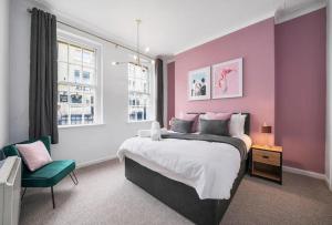 a bedroom with a large bed and a chair at Spacious 3 Bedroom Flat in Central Bath - Sleeps 8 in Bath