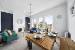 a living room with a wooden table and blue chairs at Spacious 3 Bedroom Flat in Central Bath - Sleeps 8 in Bath