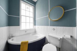 a bathroom with a tub and a toilet and a mirror at Spacious 3 Bedroom Flat in Central Bath - Sleeps 8 in Bath