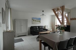 ein Wohnzimmer mit einem Tisch und einem Sofa in der Unterkunft Les Galets bleus in Le Crotoy