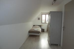 ein kleines Schlafzimmer mit einem Bett und einem Fenster in der Unterkunft Les Galets bleus in Le Crotoy
