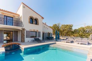 een villa met een zwembad en een huis bij Mas Sureda - Evasion luxueuse avec vue panoramique in Argelès-sur-Mer