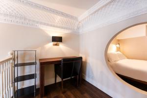 a room with a bed and a desk with a mirror at Luxury One Bedroom Mezzanine in Paddington in London