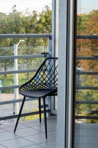 une chaise assise sur une terrasse couverte donnant sur une fenêtre dans l'établissement Apartament Wojskowa 1 / City Park, à Poznań