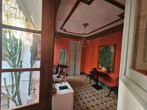 un couloir aux murs orange et une chambre avec un piano dans l'établissement Fabrica de Sueños, à Gandía