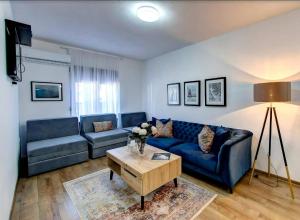 - un salon avec un canapé bleu et une table dans l'établissement Guesthouse Check In, à Stolac
