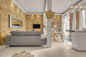 - un salon avec un canapé et un mur en briques dans l'établissement Le Cilaos - Superbe appt en centre ville, à Toulouse