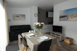a living room with a table and a couch at Les Dunes Blanches in Le Crotoy