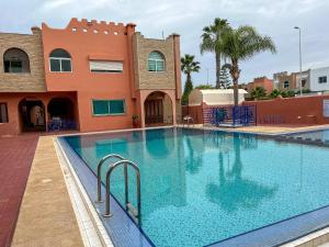 a large swimming pool in front of a building at lux appartement avec piscine in El Jadida