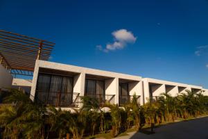 a building with palm trees in front of it at Nanii Hotel in São Miguel do Gostoso