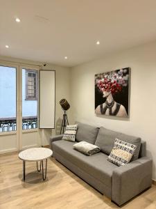 Una sala de estar con un sofá gris y una mesa. en A Das Marias, en Ourense