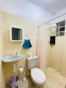 a bathroom with a toilet and a sink and a tv at Maravilhosa Kitnet 10 min da praia in Vila Velha