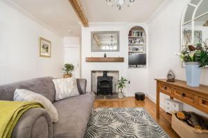 a living room with a couch and a fireplace at Bijou Cottage in Deal