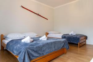 two beds in a room with blue sheets at VacationClub - Ski Lodge Szczyrk Pokój 3 in Szczyrk