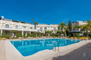 a swimming pool in front of a large building at Newly Refurbished 2 BDRM Amazing Complex w Pools in Marbella