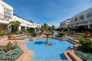 a fountain in the middle of a courtyard with buildings at Newly Refurbished 2 BDRM Amazing Complex w Pools in Marbella