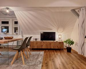een woonkamer met een televisie en een tafel bij Fewo im Harz für 4 Gäste mit optionalem Brötchenservice in Zorge