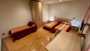 um quarto com duas camas e uma mesa em Residence Stefania Cavasso Nuovo em Cavasso Nuovo