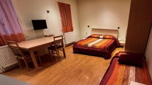 um quarto de hotel com uma secretária e uma cama e uma secretária e uma secretária em Residence Stefania Cavasso Nuovo em Cavasso Nuovo