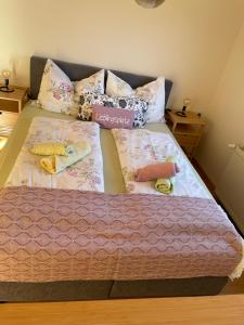 ein Bett mit zwei Decken und Kissen darauf in der Unterkunft Appartements Skruba in Steindorf am Ossiacher See