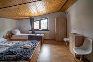 Cette chambre comprend deux lits, un bureau et une chaise. dans l'établissement VacationClub - Ski Lodge Szczyrk Pokój 4, à Szczyrk