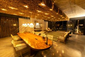 comedor grande con mesa de madera y sillas en Nanii Hotel, en São Miguel do Gostoso