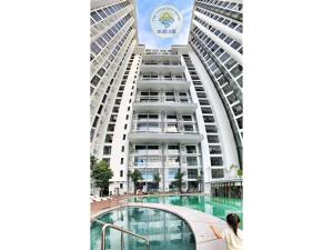 a woman stands in front of a tall building at Sea Park LeSu 8 The Shore KK I 1 plus 1 Room 2-3 Pax 홈스테이 A1710 in Kota Kinabalu