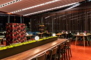 ein Restaurant mit einem langen Tisch, Stühlen und Tischen in der Unterkunft HIRSCHEN OBERKIRCH - Design Boutique Hotel in Oberkirch