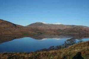 a lake with a mountain in the background at Barrachandroman Farmhouse in Lochbuie +6 photos
