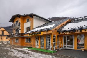 un grand bâtiment en bois avec de la neige sur le toit dans l'établissement VacationClub - Ski Lodge Szczyrk Pokój 4, à Szczyrk