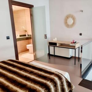 een badkamer met een bed, een bureau en een spiegel bij Exyca Ifema in Madrid