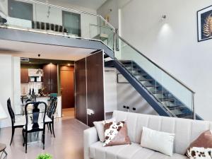 uma sala de estar com um sofá branco e uma escada em Exyca Ifema em Madri