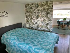 a bedroom with a bed and a table in it at Lovely Acacia in De Haan