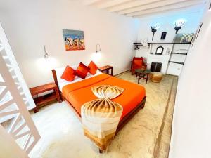 a bedroom with an orange bed and a ladder at Riad Dar Latigeo in Essaouira