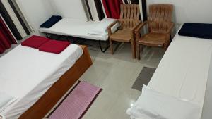 um quarto com duas camas e duas cadeiras em Ammu's home stay em Panamaram
