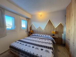 a bedroom with a large bed with a wooden headboard at Appartamento Biancaneve in Passo del Tonale