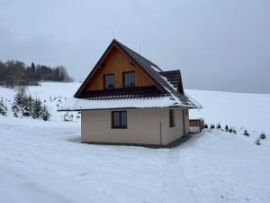 una pequeña casa con nieve en el suelo en Chata u Jána, en Zákamenné