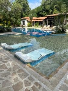 two beds in the water in a swimming pool at Kantawa Hotel & Spa - Solo Adultos in Calabazo