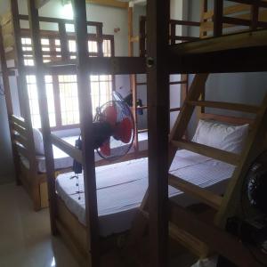 a room with two bunk beds with a fan at Sundance Beach Villa on Princess Street in Cochin