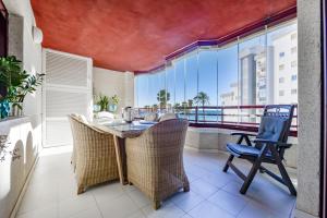 ein Esszimmer mit einem Tisch und Stühlen sowie einem Balkon in der Unterkunft Villas Guzman - Apartamento Topacio IV in Calpe