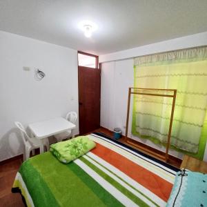 Schlafzimmer mit einem Bett, einem Tisch und einem Fenster in der Unterkunft Bella Guest House in Chachapoyas