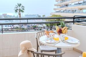 un tavolo con cibo su un balcone con vista sulla spiaggia di OBSIDIAN Estudio Santa María ad Adeje