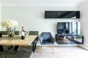 a living room with a table and a tv at Olive Tree Townhouse, with parking in Whitstable