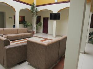 ein Wohnzimmer mit Sofas und einem Flachbild-TV in der Unterkunft HOTEL COLONIAL in Ipiales