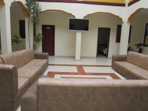 ein Wohnzimmer mit 2 Sofas und einem Flachbild-TV in der Unterkunft HOTEL COLONIAL in Ipiales