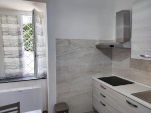 uma cozinha branca com um lavatório e uma janela em Country House Ortensie em Torre del Greco