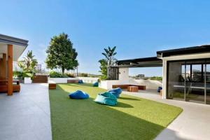 una casa con un patio con césped verde y objetos azules en Boutique Park-view 1BR Apartment, Central location en Brisbane
