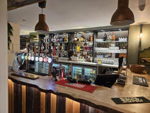 a bar with a counter with a lot of alcohol at The Garden Bar Rooms in Baildon