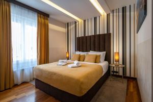 Apartments Feel Belgrade في بلغراد: غرفة نوم بسرير كبير عليها منشفتين